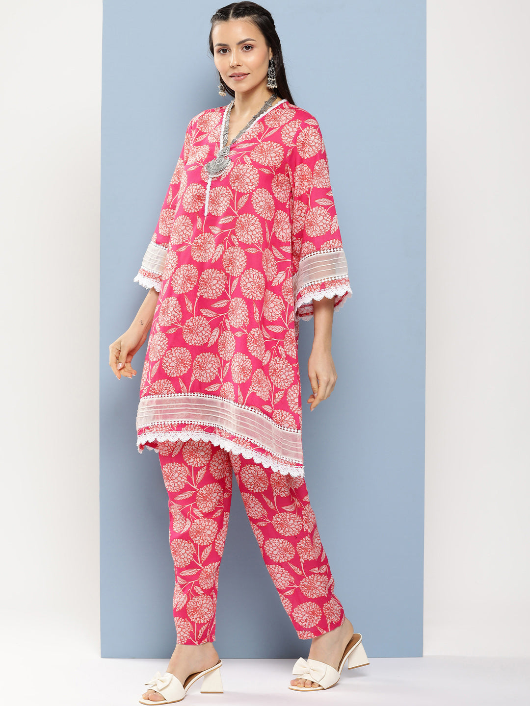 Bhama Couture Pink Floral Print A- Line Kurta With Lace Detailing & Pink Floral Print Trousers.